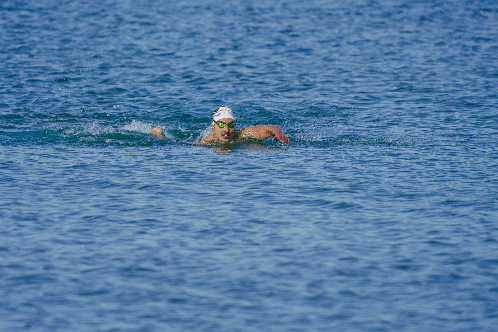 Open water swimmer doing dryland shoulder exercises with resistance band