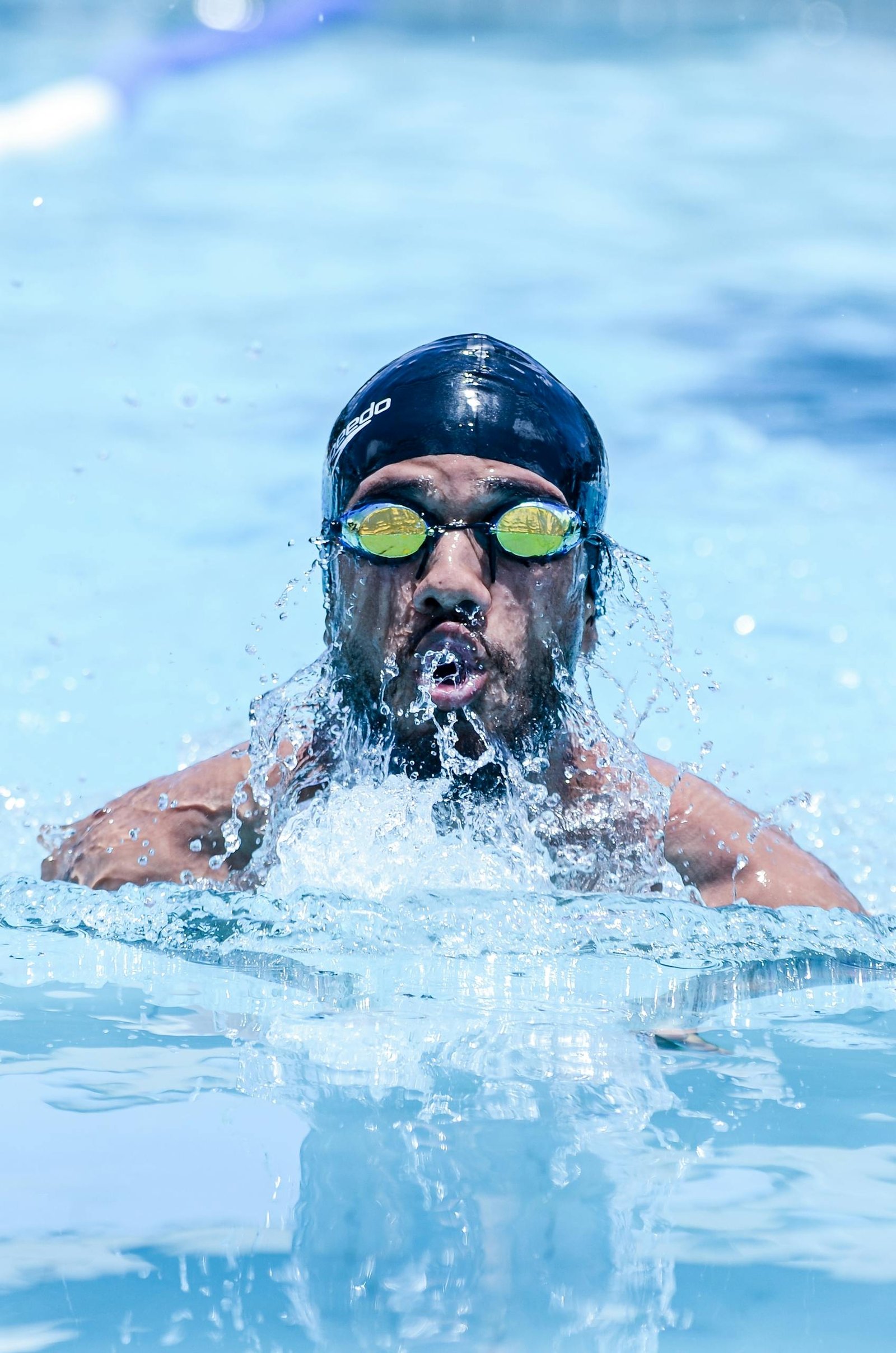 Close-up of an athlete swimming intensely in a bright outdoor pool.