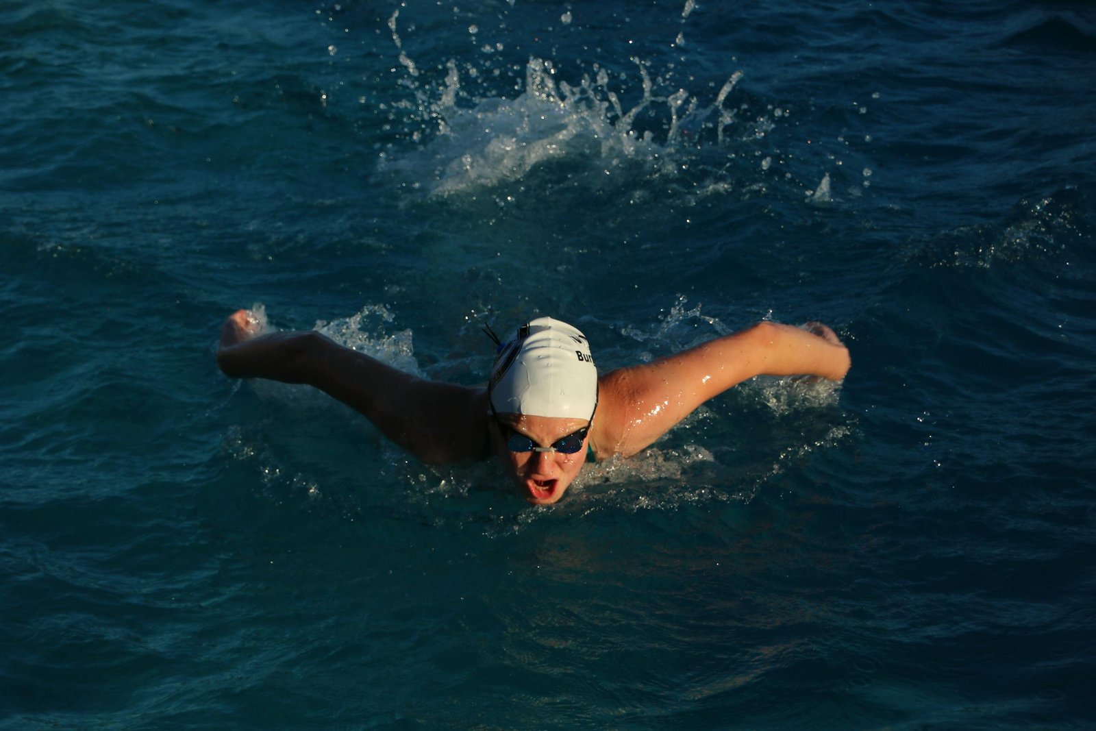 Open water swimmer training in a lake with swim goggles
