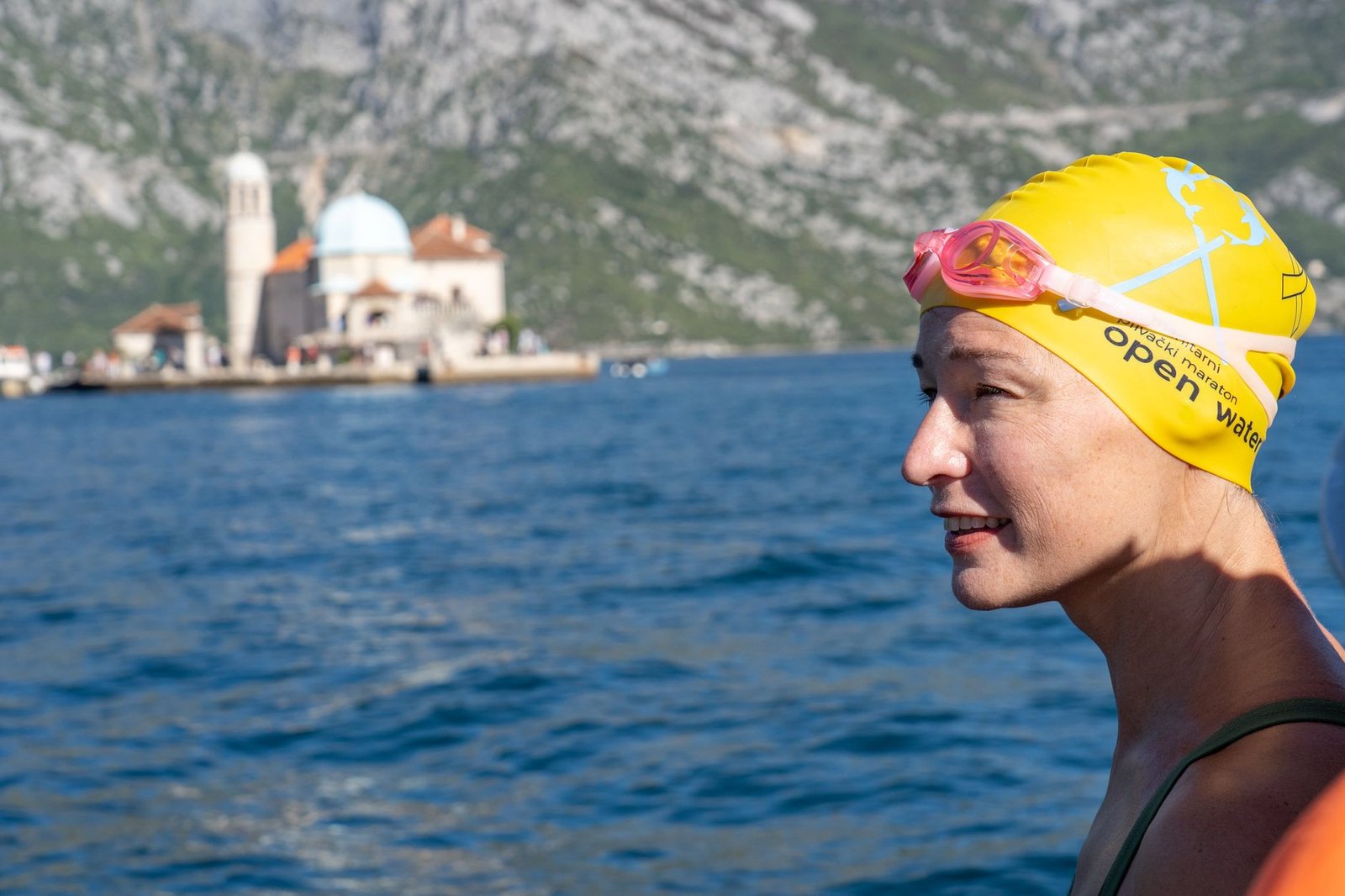 Open water swimmer adjusting goggles before a lake or ocean swim