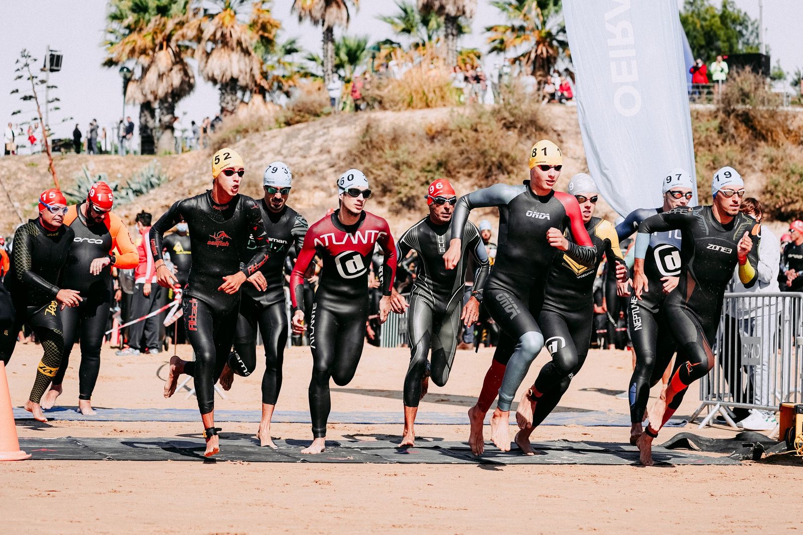 Triathlon swimmer adjusting goggles before an open water race start