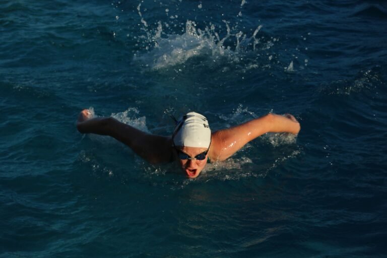 Beginner open-water swimmer adjusting goggles before a lake swim