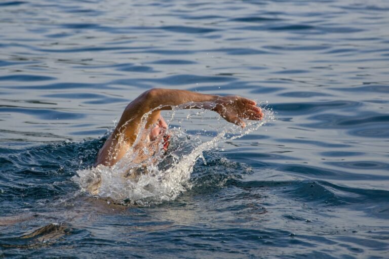 Open-water swimmer wearing goggles in bright side glare