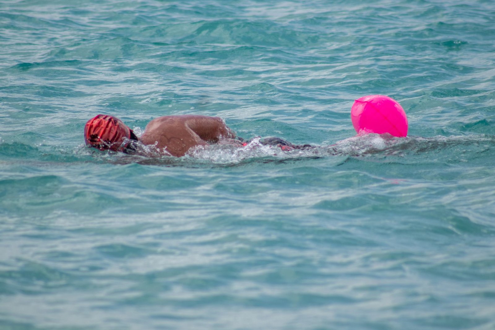 Open-water swimmer adjusting goggles before a saltwater swim