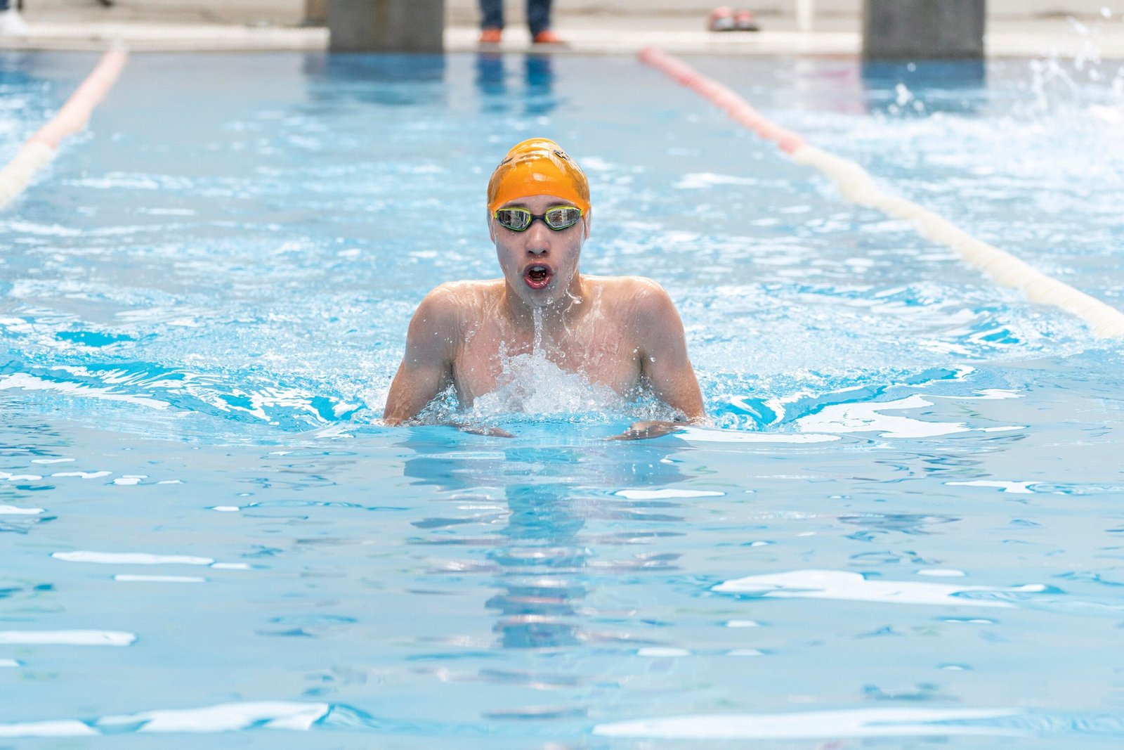Swimmer testing goggles in a pool before using them in open water