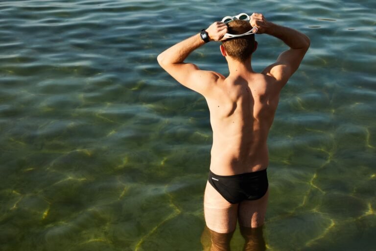 Open-water swimmer preparing goggles before a lake or ocean swim