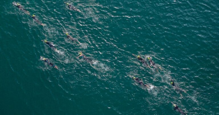 Group of triathlon swimmers racing together in open water
