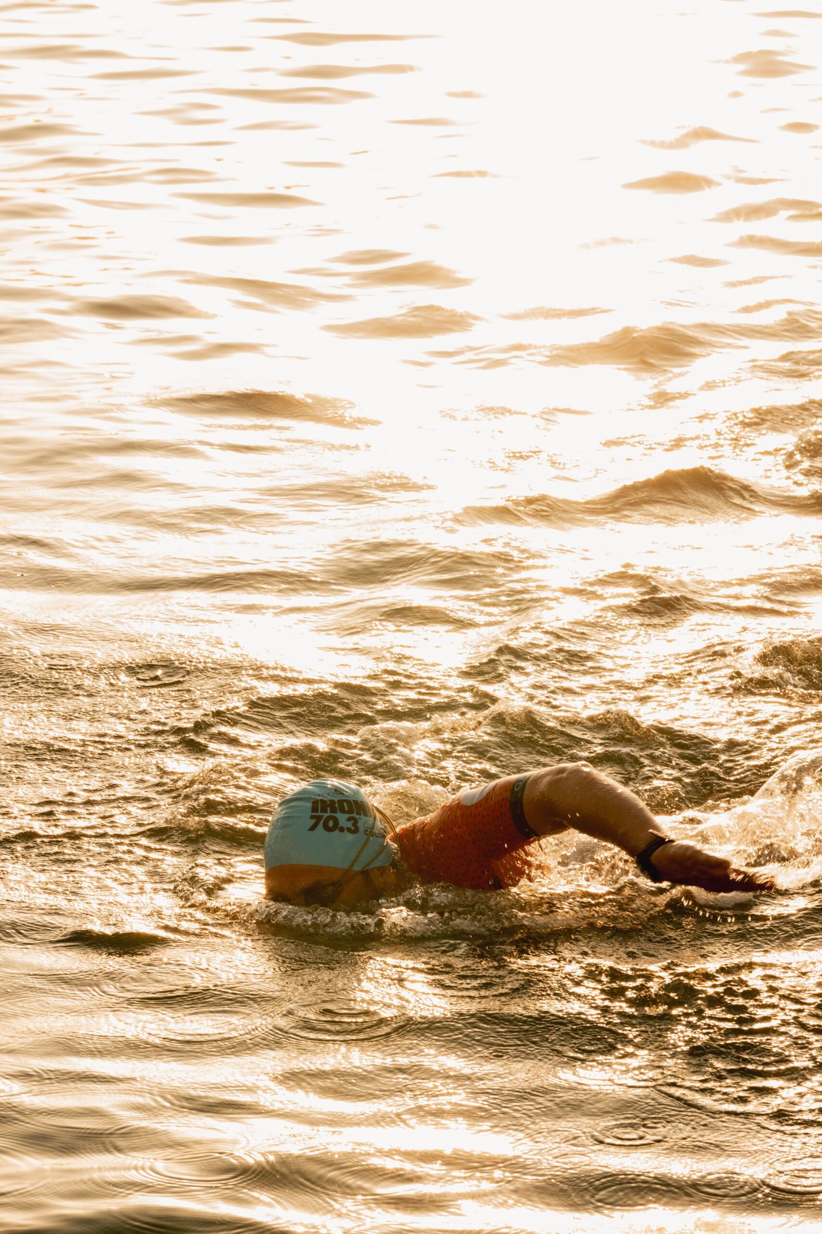Triathlete swimming in open water with goggles during race conditions